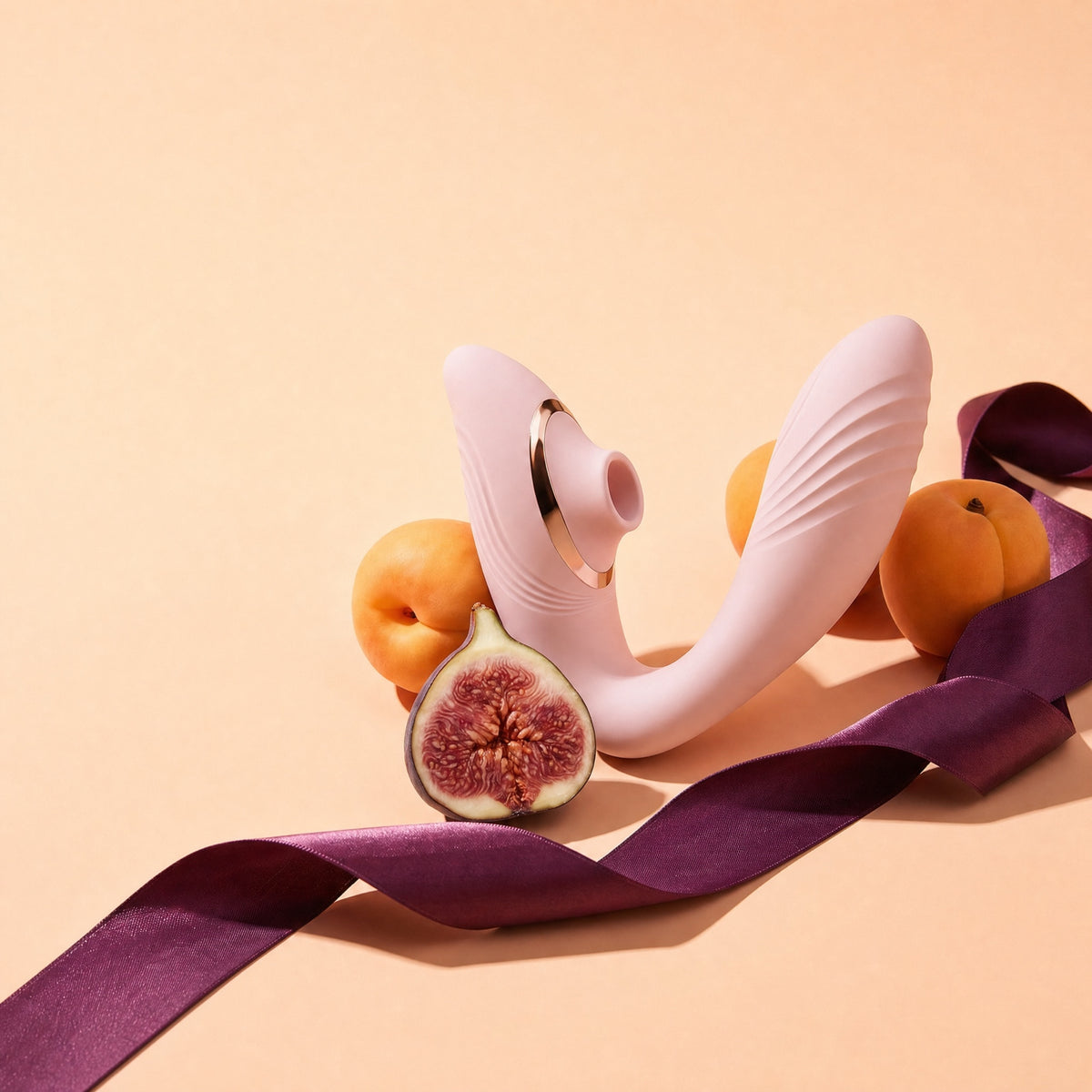 LILA Pulse rose posé sur des abricots, une figue coupée et un ruban de satin prune